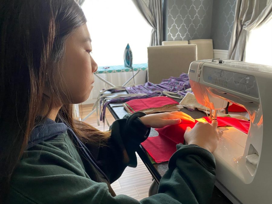 Sewing two layers of a mask together, freshman Hannah Choi creates masks to donate to BJC hospital, the police department and nursing homes. Choi’s neighbor gave her the idea to donate masks to first responders. “This is the first time I’ve ever sewn, so it’s new to me, but sewing is helping me pass time. Once you start, it’s kind of addicting, and it takes away my boredom,” Choi said. 