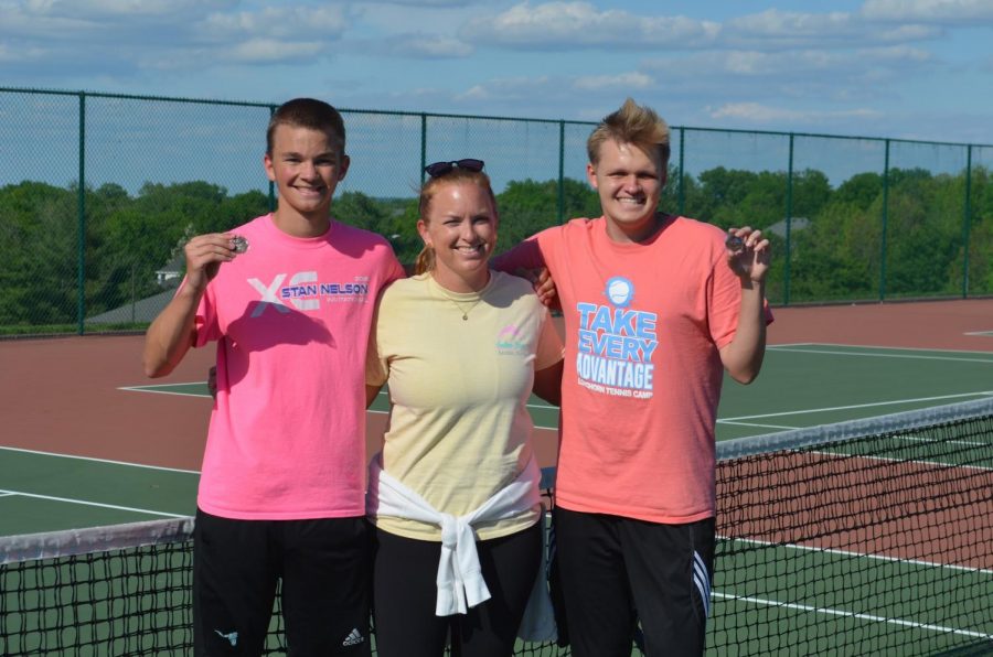 Holding+their+third+place+medals+from+districts%2C+senior+Robert+McKnight+stands+alongside+his+teammate+Matt+Boyd+and+tennis+coach+Katelyn+Arenos+after+a+practice+during+their+junior+year.+They+spent+most+of+their+season+playing+doubles+matches+with+each+other.+%E2%80%9CPlaying+tennis+has+taught+me+a+lot.+Staying+committed+to+my+training+has+taught+me+discipline.+Struggling+through+back+injuries+has+taught+me+how+to+always+find+the+silver+lining.+Most+importantly%2C+my+tennis+career+has+taught+me+a+lot+about+humility+and+respect%2C%E2%80%9D+McKnight+said.+%E2%80%9CRespect+is+earned+in+many+ways.+It%E2%80%99s+about+correcting+your+mistakes+and+putting+others+first%2C+and+improving+the+lives+of+those+around+you%2C+because+you+%5Bcan%5D+personally+have+an+impact.%E2%80%9D