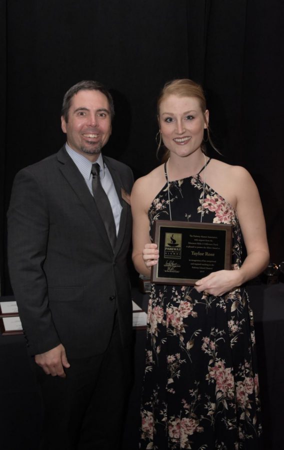 English Teacher Taylor Rose holds up a plaque of her Albert Award from the Parkway Alumni Association in 2019. 