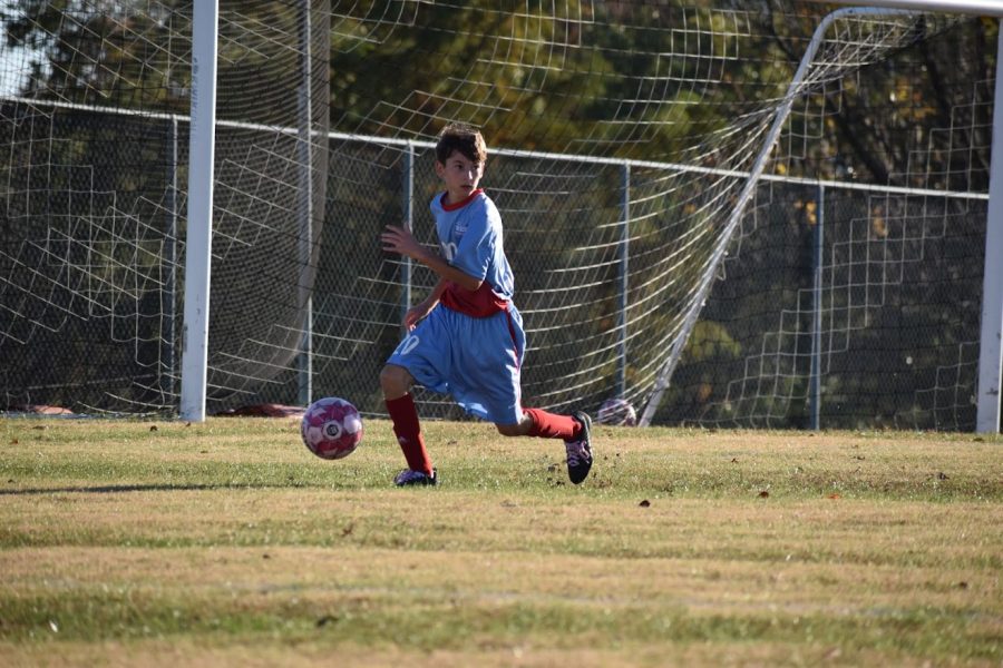 During a home game against Clayton Oct. 22, freshman Josh Seager kicks the ball away from the goal. Seager and his team played in honor of breast cancer awareness month. The highlight of the game was honoring those affected by cancer, and even winning the game, Seager said. 