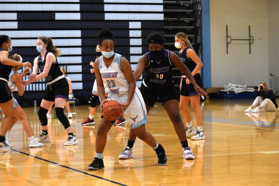 Weighing her options, junior Shemaiah Saunders aims to pass the ball and cut to the basket for a shot. This season, Saunders has had to play her games while wearing a mask. It’s difficult [with] other kids playing sports trying to breath and feel comfortable, Saunders said. But COVID-19 hasn’t really changed much... I’ve known most of my teammates since elementary school, so it’s just cool to continue to play with them and graduate with them.