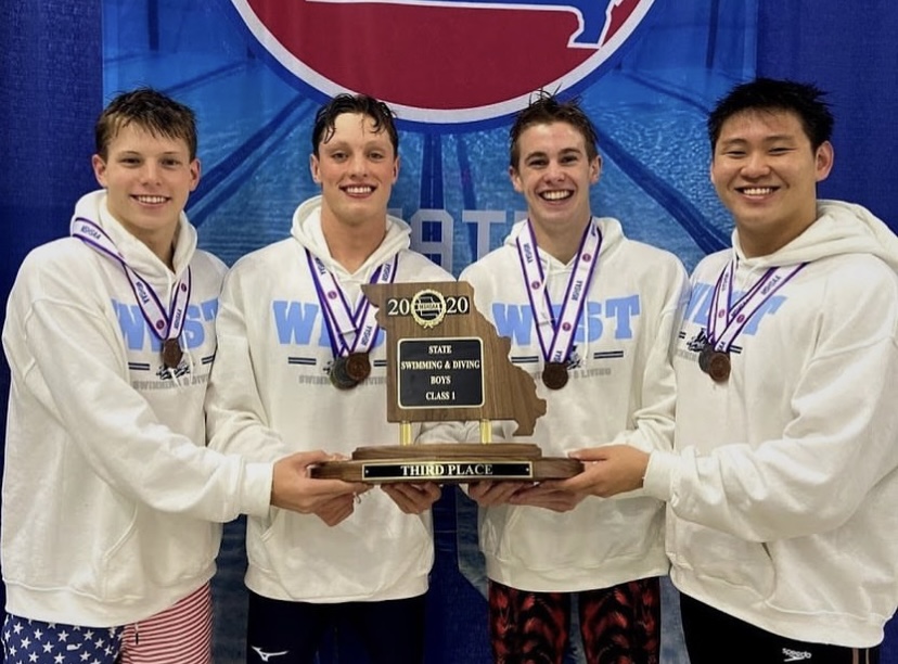 After earning third place in the 400 freestyle relay, seniors Carter Murawski and McKay Morgan hold their trophy with juniors Will Bonnett and Raymond Yoon.