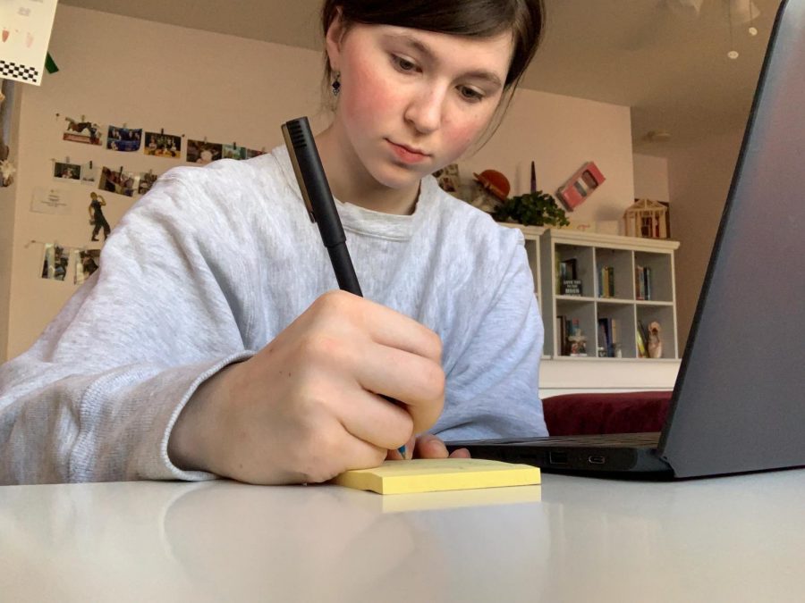 At her laptop, junior Ellie West takes notes on a pad. West is currently in Virtual Campus High. I like to use sticky notes for individual thoughts, West said. I like that I can put them on my wall or move them around. 
