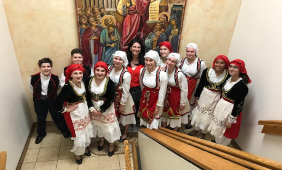 After performing for Assumption Greek Orthodox Church, freshman Thalea Afentoullis (second to the left in the front row) poses for a picture with her class and mom. Afentoullis enjoys hanging out backstage before and after performances with her classmates and friends. “Whenever we are not dancing, we are always backstage because we have to be ready, and we have our own dressing rooms. I just remember there being so many fun stories and we would all just eat together and be really funny,” Afentoullis said.