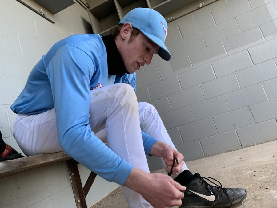 Preparing for baseball tryouts, senior Jack Meert ties the laces of his cleats. Meert is back after being cut a year ago. Im excited for my senior season, Meert said.