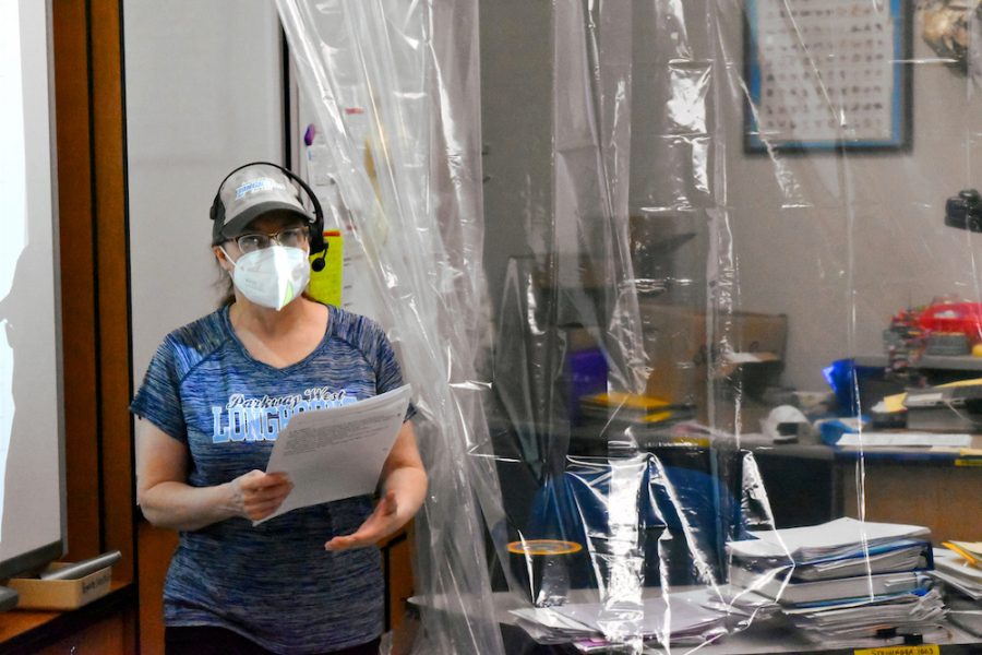 Teaching behind a clear shower curtain, biology teacher Sally Soulier focuses on teaching her students while maintaining social distance. Soulier suffers from hearing loss and had difficulty hearing students through their masks. “It is so hard to get to know people without their faces, and students likewise can’t see me smiling,” Soulier said. 