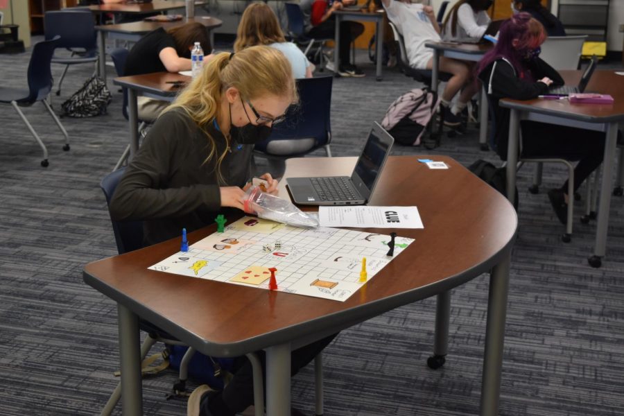 In the library with her Honors English II class, sophomore Alexandra Toombs constructs a board game, Othello Clue. A Shakespearean twist on the original game, the objective is to try to guess who, where and with what item someone is trying to woo your (Othellos) wife, Desdemona. I thought the assignment was very fun, because I got to create stuff and look at the play in a different way, Toombs said. One hardship I encountered was I could not find game pieces, so I made my own out of Legos.