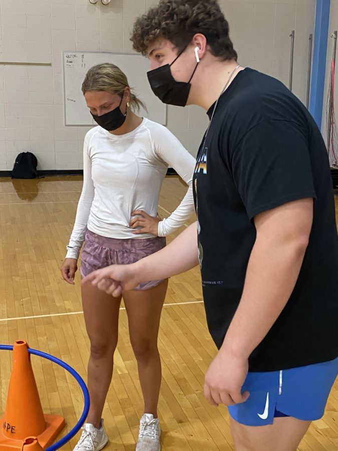 Senior Connor Combs teaches junior Ella Mercer how to play hula soccer.