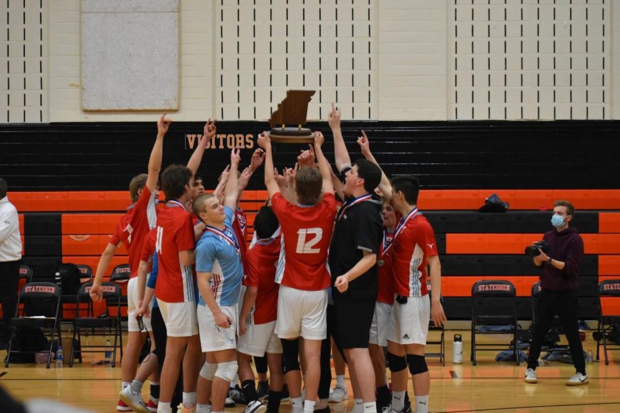 After scoring the winning point, senior Matt Cosgrove holds the State Champions plaque above his teammates. Seconds later the crowds stormed the court in celebration. “It was just unreal. I was speechless to finally win after talking about it for more than a year.  Unreal feeling,” Cosgrove said. (Photo courtesy of Matt Cosgrove)