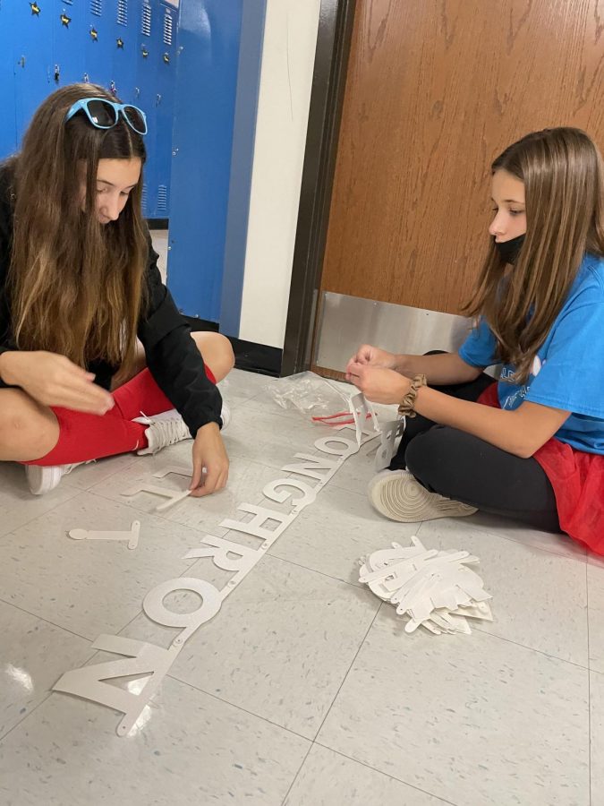 Sporting West spirit, freshmen Sophia Licavoli and Gabbie Catlett sit in the hallway while making float decorations for the volleyball float in the parade. The two wore red tutu’s to support the activities of spirit week. “I liked sharing school spirit and seeing everyone dress-up and have fun,” Licavoli said. “It was a great week.”