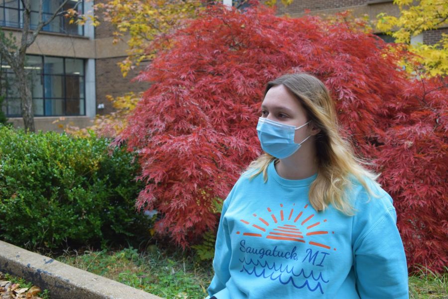 Senior Shannon Dobson sits on a curb, posing for a photo. 