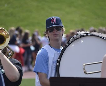 Senior Kyle Schultz awaits the homecoming pep rally performance. Rallies and halftime performances helped Schultz in preparation for the series of Bands of America Honor Band performances. “Performing in front of hundreds of people is normal to me now. When I was a freshman in color guard, I would get really nervous, but now there's nothing better than being able to show off what we’ve worked on and everyone gets a kick out of it,” Schultz said. “I’m so used to playing when it’s loud at big school events, so when I’m in the quiet setting of a competition it feels a lot more tense.”  [Photo courtesy of Sophia Johnson]