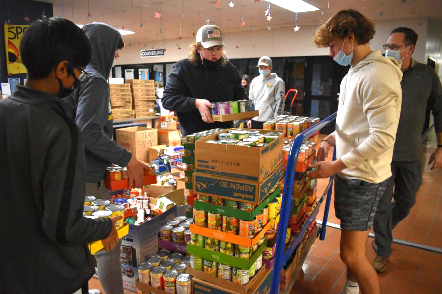 Stacking+cans+of+food+for+Chazen+vs.+Wayland+canned+food+drive%2C+seniors+Bryce+Drake+and+Aamon+Naig+work+together+to+load+the+cart.+Chazen+vs.+Wayland+is+a+longstanding+campus+tradition+between+social+studies+teachers+Jeffrey+Chazen+and+Annie+Wayland%3B+Wayland+defended+her+title+as+champion+and+Chazen+added+to+his+now+14-year+losing+streak.+We+all+put+our+best+foot+forward+and+spent+a+couple+of+hours+filling+the+carts%2C+it+felt+great+to+be+a+part+of+something+so+neat+and+we+all+had+a+fun+time+doing+it%2C+Drake+said.+++