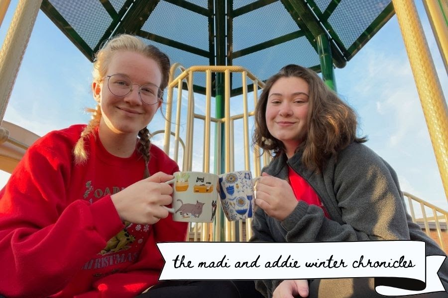Madi and Addie clink their mugs together on a playground.