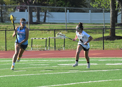 In a lacrosse game against Lafayette, junior Maddie Humme passes the ball to her teammate. Although the girls’ varsity lacrosse team lost the game April 26, the team maintained their unity and team spirit. “[This game] stuck out to me because we were really high-energy. We didn’t lose hope,” Humme said. “[My favorite part] was really getting to have a different experience each game.”
