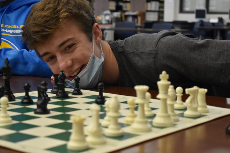 Smiling at the board and checking for placement, sophomore Brett Summa is excited to start another round. Summa was a new member to the chess club which offers much more than tournaments and accolades to the students. “I enjoy the fellowship and friendliness of the people and I have made many new friends at the club,” Summa said. 
