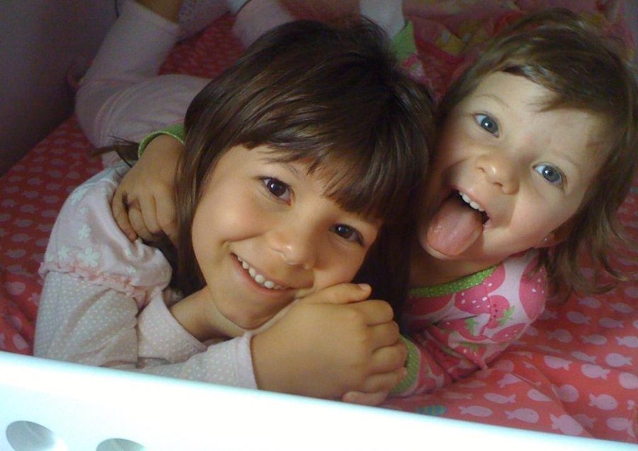 Sticking her tongue out playfully, 3-year-old Clara DAquino Lazarini tightly holds her sister. In Brazil, when the two shared a bedroom, many fun memories were made — however, there were the occasional light-hearted disputes. “I would always try to sneak into her bed at night because she had [the] top bunk, and I was so upset that I didn’t have it,” Clara said. “I used to talk while I was sleeping, and every morning she would tell me the things I said or did, and she would always pretend to be mad at me, but in the end, shed laugh about it with me.”