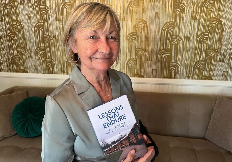 Former Principal Beth Plunkett poses with her memoir “Lessons That Endure: Reflections of a High School Principal.” 
