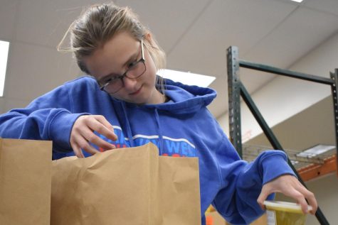 Packaging four containers of curry per bag, senior and Parkway Food Pantry volunteer Kailey Hartle helps with the food pantry’s distribution every month. Hartle was grateful for the leadership skills she learned through working with the food pantry for a year. “It feels like I have the most direct impact. I am helping families that have enough food to make it through the month,” Hartle said.
