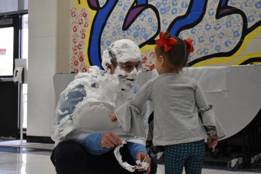 Greeting+his+3-year-old+daughter+Molly+McCabe%2C+Principal+John+McCabe+smiles+after+getting+pied+in+the+face+by+senior+Esha+Francis+during+lunch.+McCabe+got+pied+as+a+reward+for+school+spirit+at+the+Parkway+Holiday+Cup+Volleyball+Tournament+on+Wednesday+Dec.+14.+%E2%80%9C%5BMolly%5D+just+started+her+first+year+of+Pre-K+and+shes+loving+it.+I+told+her+all+weekend+I+was+getting+pied+and+she+thought+it+was+really+funny%2C+so+she+just+wanted+to+see+dad+getting+pied.+She+loved+it+but+she+told+me+she+was+a+little+bit+scared+because+she+didn%E2%80%99t+recognize+me%2C%E2%80%9D+McCabe+said.