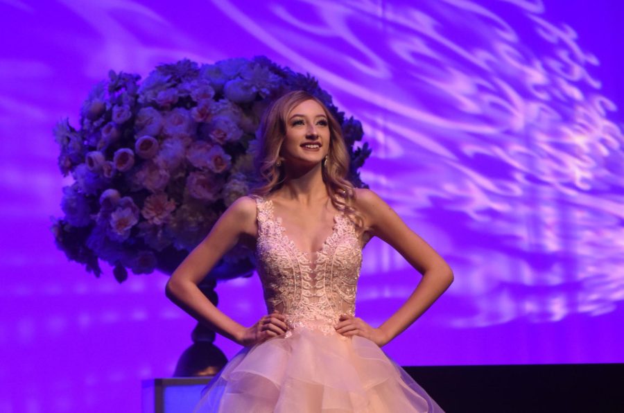 Eyes to the sky, junior Romy Taylor stands center stage in the evening gown section of the 2023 Miss Missouri Teen Volunteer Pageant. Taylor received compliments from judges and the audience for her walk, a skill she believes this section allows contestants to flaunt. “[Walking on stage in a gown] shows how much grace someone can carry. I absolutely love it when I get to show it off on stage,” Taylor said.