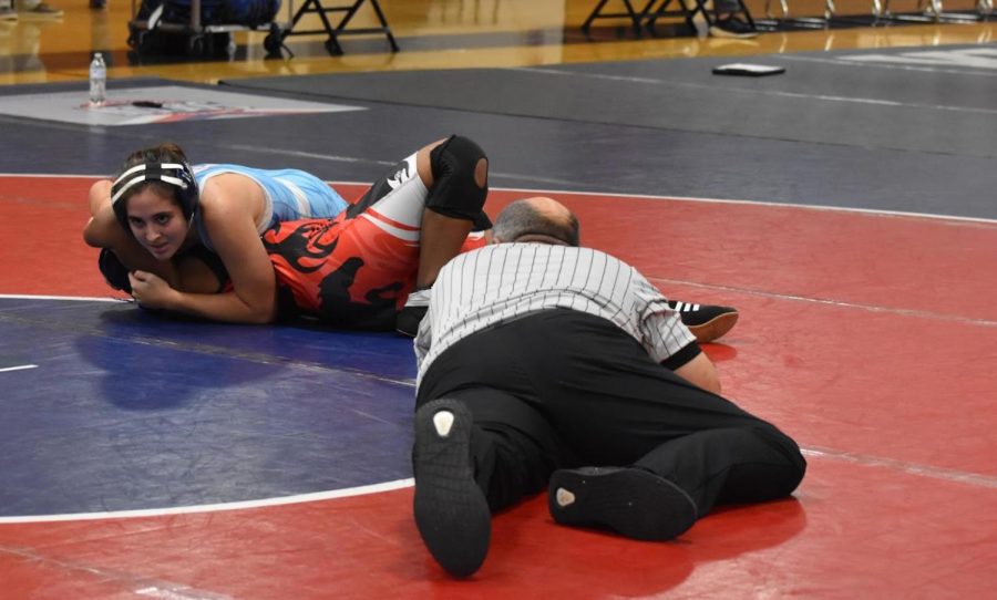 Senior Lydia Brazier pins her opponent, sophomore Savannah Robbinson, in the first minute of their match with a half-nelson, scooping Robbinson’s head while pressing down on her chest. Brazier’s seventh season pin earned her the win against Parkway Central at the Parkway Invitational. "Wrestling is not as terrifying a sport as people say it is; it gets easier as you get older. The more that I do that move, the more it's instinct rather than just me trying to do it," Brazier said.