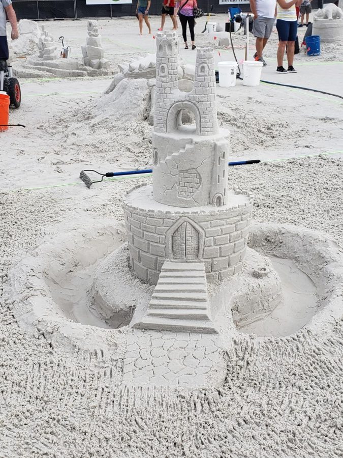 As their first sand sculpture competition ends, English ASC teacher Kristen Witt and her husband capture their creation standing tall. The two had only taken one lesson before participating in the amateur division 2021. “We had a moat that came over and out of our sandcastle, and it collapsed. We kept trying to rebuild and rebuild it, [but] that part didnt work. We had to do something else, so we built a smaller bridge that went over. It wasnt how we wanted it to be, but we did our best,” Kristen said.