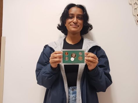 Holding up five of her favorite uncirculated coins, sophomore Anshu Chappidi shows off a small portion of her family’s coin collection.