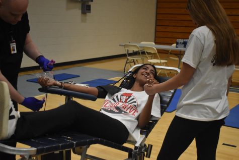 After three months of preparation for the first annual blood drive, National Honor Society (NHS) President and senior Nikita Bhaskar lays in one of the stretchers holding senior Jame Wild’s hand as she donates blood. The blood drive gathered 61 bags of blood to donate to ImpactLife. “I loved seeing the NHS volunteers shine. Katie Jauss, Jame Wild and [senior] Adam Lancia choreographed dances to perform in front of the donors to distract them, and it genuinely brightened the event. They let their personalities shine to help others, and I felt thats what NHS is all about. It was inspiring to see,” Bhaskar said. “Knowing that I could save three lives by donating a pint of my blood made it a no-brainer; donating was an easy choice.