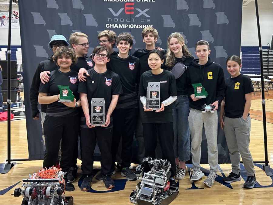The+Blue+Brains+Robotics+Team+and+supporters+pose+together+after+winning+State+and+qualifying+for+Worlds.+Teammates+hold+Second+place+Skills%2C+Tournament+Champion+and+Excellence+Award+trophies+as+the+competition+comes+to+an+end.+%E2%80%9CIt+was+such+an+amazing+experience+to+not+only+double+qualify+for+Worlds%2C+but+to+do+it+with+my+teammates+who+are+some+of+my+favorite+people+in+the+world.+I%E2%80%99m+really+glad+I+get+to+continue+competing+for+my+senior+year%2C%E2%80%9D+Senior%2C+Notebook+Writer+and+Drive+Team+Member+Katherine+Hanses+said.