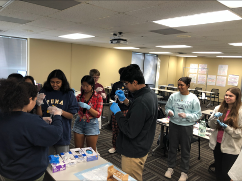 Spark! Pre-Professional Health Sciences Academy students wait in line to receive water samples to practice handling test tubes and droppers.