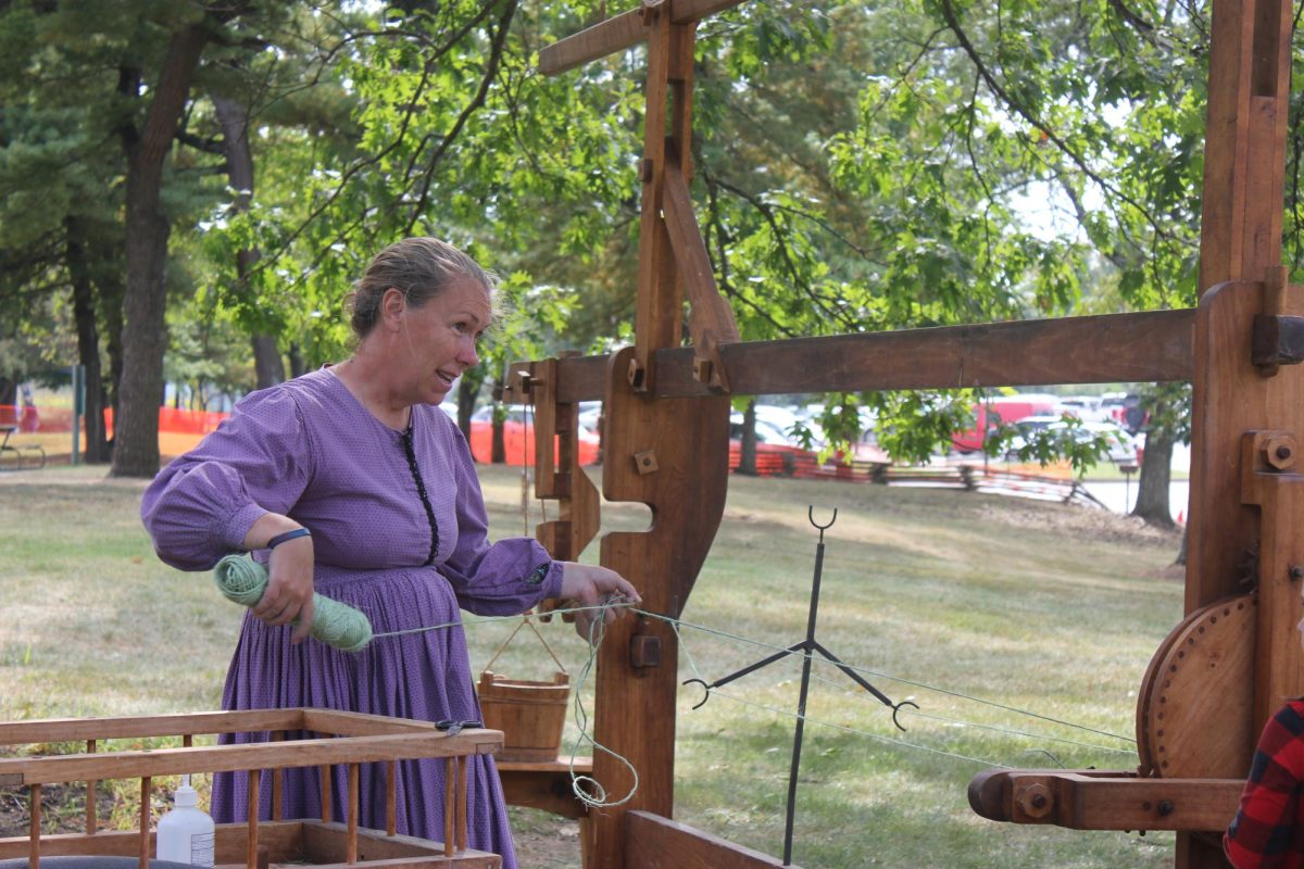 Working at the annual Folklife Festival, an event leader demonstrates the use of a four post box loom. Created in England during the 16th century, the four post box loom allowed weavers in the Northeastern colonies to weave fabric more efficiently than before, playing an essential role in the evolution of settler culture. “Walking around the festival, you could see how people actually lived in the past — what theyd do for fun, how they survived. It was really interesting to see how different it was from now. You could put yourself in the shoes of the people back then,” senior Jojo Shank said. 