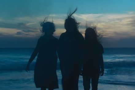 Silhouettes against the sky, the members of boygenius look out over an ocean. Composed of singer-songwriters Phoebe Bridgers, Lucy Dacus and Julien Baker, the trio released their second EP, “the rest” on Oct. 13. The band has accumulated almost 4.5 million monthly listeners on Spotify. (Photo from xboygeniusx.com)