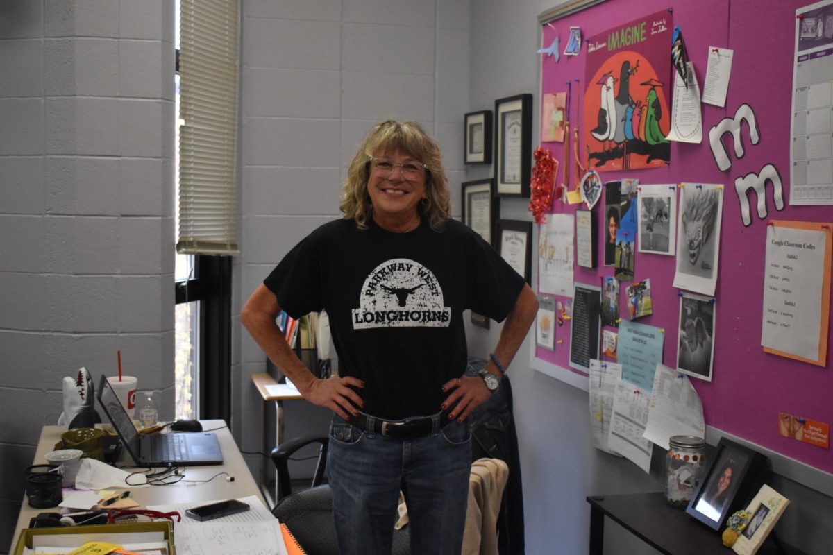 English teacher Angela Frye stands behind her desk in her classroom. Frye went through a lot of personal struggles to get to where she is today, and with each step in her life, she carries her gratitude for those obstacles. “Everything happens for a reason. I believe in [the concept of] good energy, good karma, [from] being a good person. Those are things I dont take lightly. [Struggles] build character. You really appreciate everything you have when you have to work for everything you have,” Frye said. 