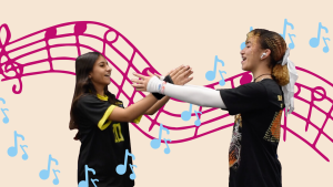 Sophomores Tina Ghasedi and Faith Kothe hold their arms out and sing to each other.