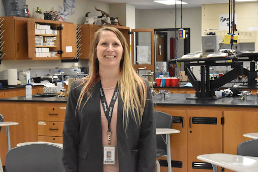 Science teacher Chloe Gallaher smiles at the camera while standing in her classroom.