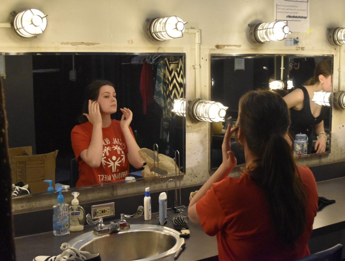 Prepping for her performance, senior Presley George applies her makeup for the opening night of “The Curious Incident of the Dog in the Night-Time.” Though George had a minor role in the play, she still had to practice getting show-ready for an audience. “I like doing my makeup because I get chances to do looks that I might not normally do. During opening night, these makeup skills are put into practice and jitters start to kick in. Opening night is definitely the scariest and [when] I get nervous, I try to walk around and talk to my friends to help calm myself down. But after opening night, I feel okay and I feel like ‘I got this,’” George said.