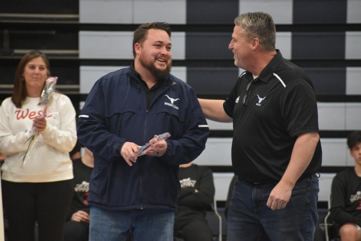 Laughing, boys wrestling head coach Zeke Allison and assistant coach Jeff Scholte celebrate their athletes on senior night. The two have coached together since the 2015-16 season. “I couldn’t get to those 100 wins if it wasn’t for the people that I coached with. My dad coached with me for a while. Right now, I got [assistant coaches] Murry Reich and Jeff Scholte, who’ve been with me most of the way. I definitely couldn’t have done it without those guys being in my corner,” Allison said.
