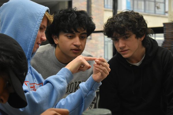 Gazing at a tube of DNA, sophomores Matthew Barry, Tawqir Farooq and Colby Yates participate in an experiment in Honors Biology. Students were exploring their DNA by analyzing a soy and alcohol mix. “[My favorite part] was getting to do the experiment with my friends. It was just a lot of fun. [I like] getting to explore what life is made of [in biology class],” Barry said. 