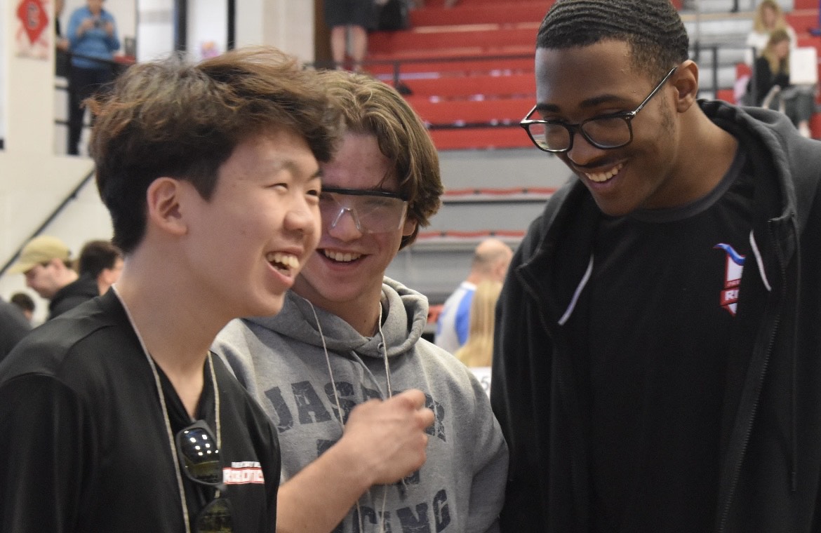 Seniors Andrew Son (left), Tommy Eschbach (center) and Kaiden Kelley (right) laugh together while waiting for their robot, OverDriv6, to compete at the 2024 Missouri VEX State Championship. Although the competition was stiff, the trio managed to have a good time, content with their performance and teamwork. “We’re very good at recognizing small victories while in the face of adversity. If one of our subsystems failed or one of the parts of our robot broke, wed spend half an hour or so fixing that. The next match, even if we lost, wed still celebrate the fact that that adjustment we made ended up working and succeeding. Being able to celebrate minor victories was very good for our team chemistry and strength,” said Eschbach. (Photo by Mikalah Owens)