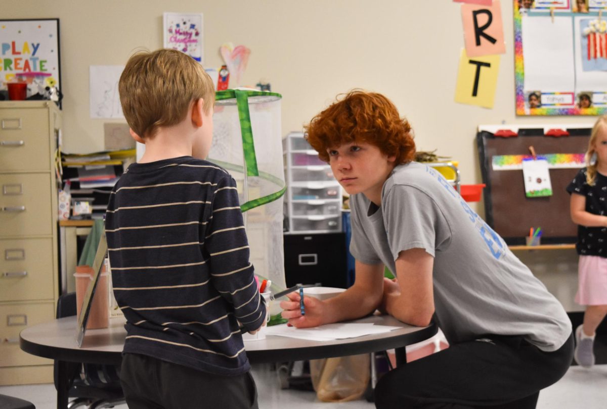 Kneeling on the floor at the Early Childhood Center, freshman Will Nunnelee holds a crayon to paper. Nunnelee listened intently as the young student described the butterfly to him. “I drew him a butterfly while he told me about it. He seemed very interested,” Nunnelee said.
