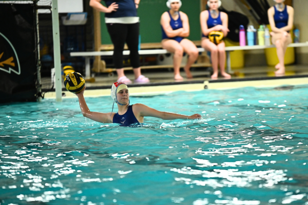 With her arms held high, junior Jenna Rickelman throws the ball across the pool during a girls water polo practice. With hours of practice after school and over the summer, Rickelman saw many improvements in her water polo skills. “When I look at [my] stats, I'm so much better than I was last year,” Rickelman said. 