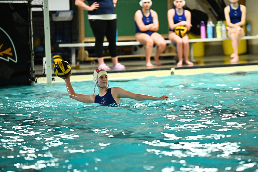 With her arms held high, junior Jenna Rickelman throws the ball across the pool during a girls water polo practice. With hours of practice after school and over the summer, Rickelman saw many improvements in her water polo skills. “When I look at [my] stats, Im so much better than I was last year,” Rickelman said. 