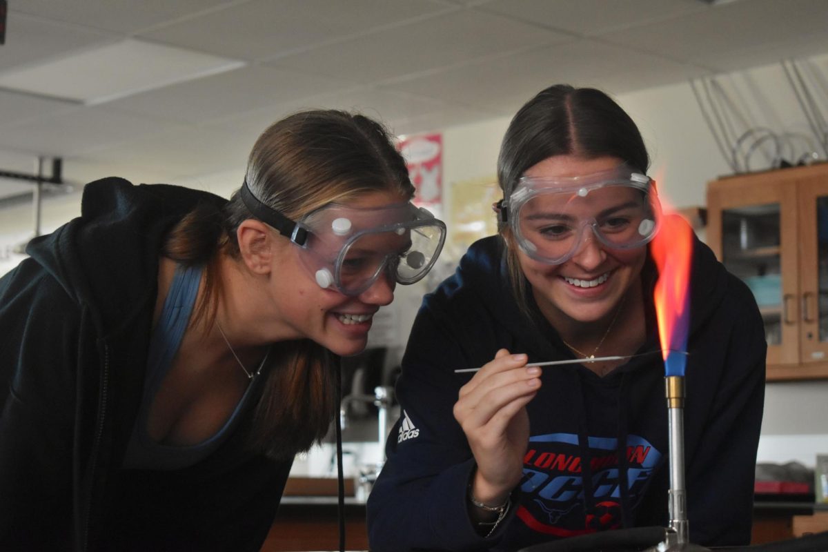 Touching various chemicals to the flame of a Bunsen burner, junior Julia Kiffer discovers how electrons impact the color of fire. In this chemistry lab, Kiffer explored eight different chemicals as her lab partner junior Kate Hardy made observations on each flame’s color and duration. "[The lab] was a lot of fun. I like doing experiments [and seeing how] things happen. We were exciting electrons and depending on the chemical, the color of the fire was different. There was a teal green chemical that was super cool,” Kiffer said