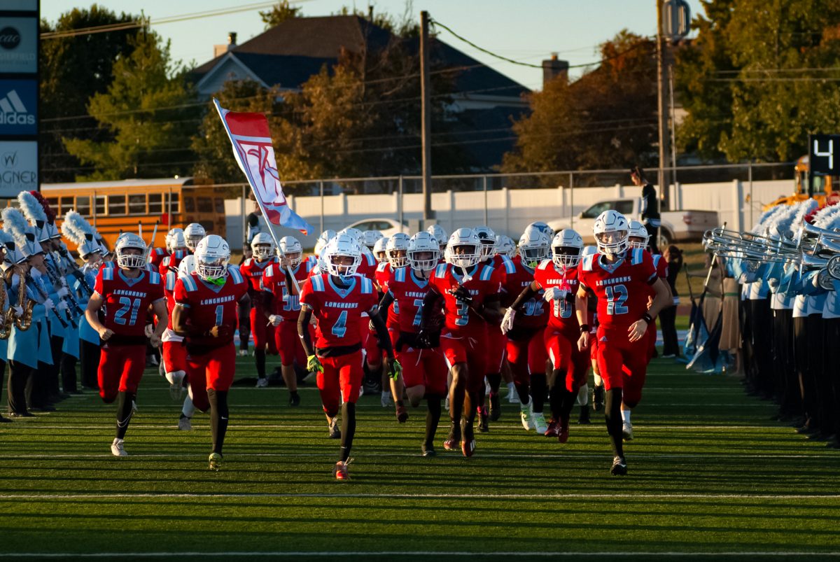 Leading the varsity football team, junior and no. 4 player Billy Lipscomb runs on to the field through two lines of marching band members. Varsity played against Pattonville on Oct. 18, marking the last home game of the regular season. “[The game] went well. I felt like I could have done better, but we executed the win. So that's all we needed,” Lipscomb said.