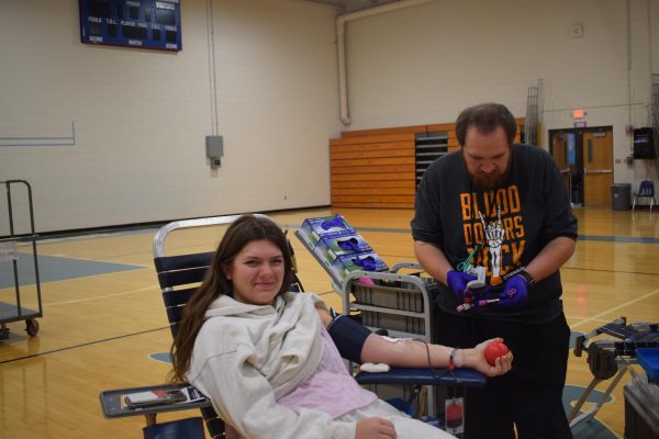 Senior Sadie Burgess squeezes a stress ball as she gets her blood drawn. Burgess was the first student donor of the day for Impact Life’s blood drive. “I'm not good with needles or shots, so giving blood made me a little nervous, but I think I did okay,” Burgess said. “I saved three lives today and I feel like Halloween is a good day to give blood. It's very festive with the vampires and the costumes.”