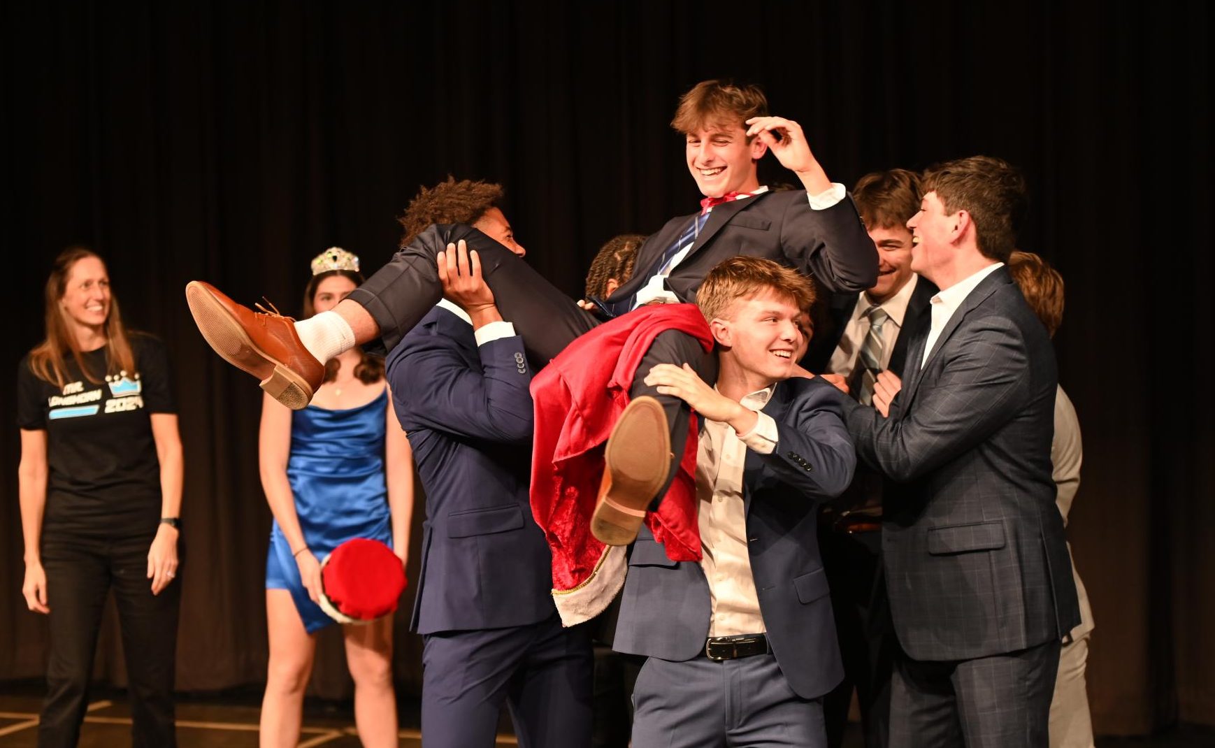 Following his victory, Mr. Longhorn and senior Henry Wild gets lifted up by fellow senior contestants in a moment of celebration. After making it into the top three of nine competitors, Wild responded to an interview question posed by senior class principal Beth Aromando to cinch the victory. “Being up there with all the boys when they're picking me up and throwing me around was a fun time. I didn't participate to win; I just did it to have fun with them,” Wild said.