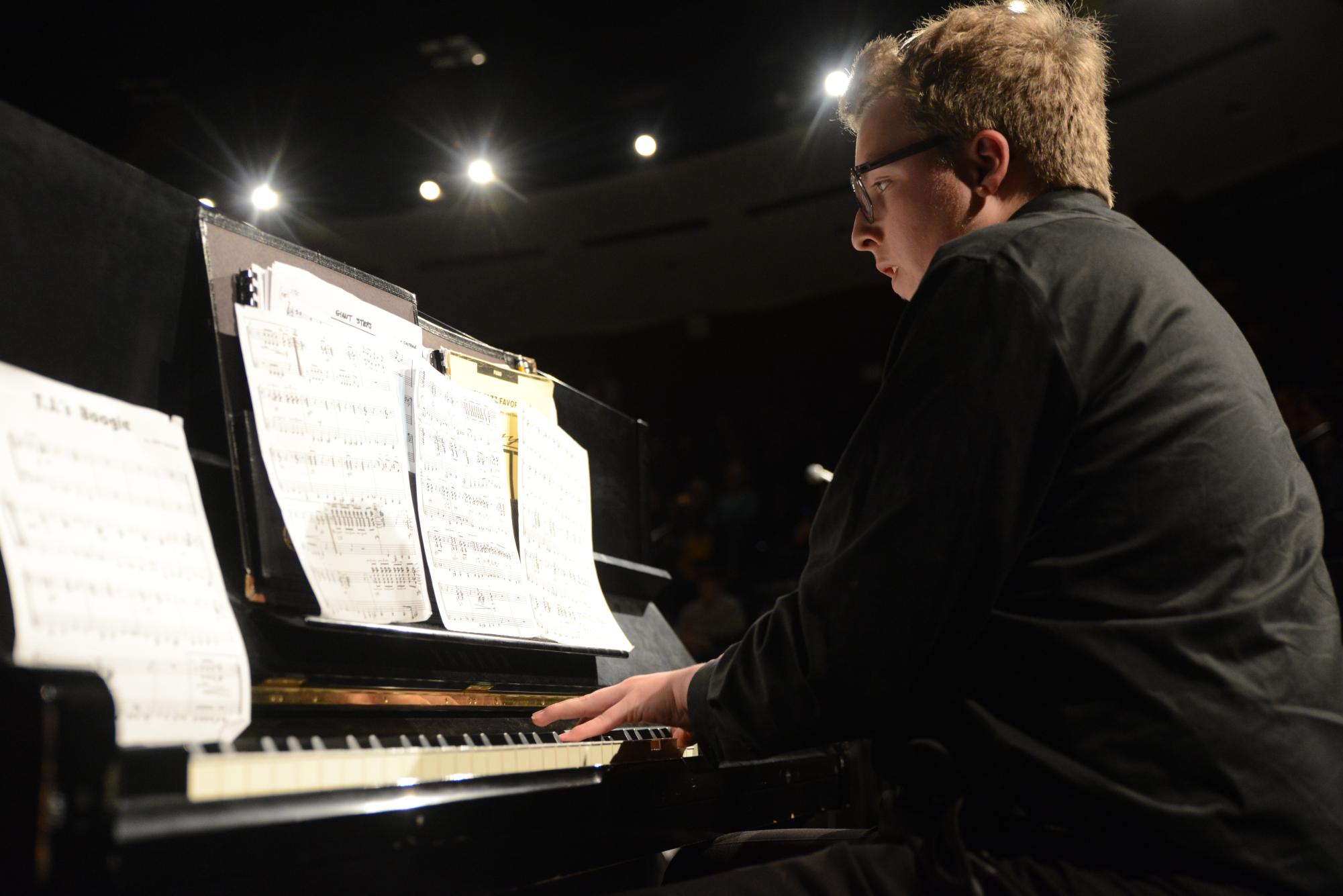 Eyes glued to his sheet music, senior Andrew Gillies accompanies the Jazz Band as the pianist. During the annual Winter Jazz Concert, Gillies was chosen to improvise a solo during the song, “T.J. Boogie.” ¨I love concerts [because of] how the audience reacts, and just the stage lights [shining on me],¨ Gillies said. 