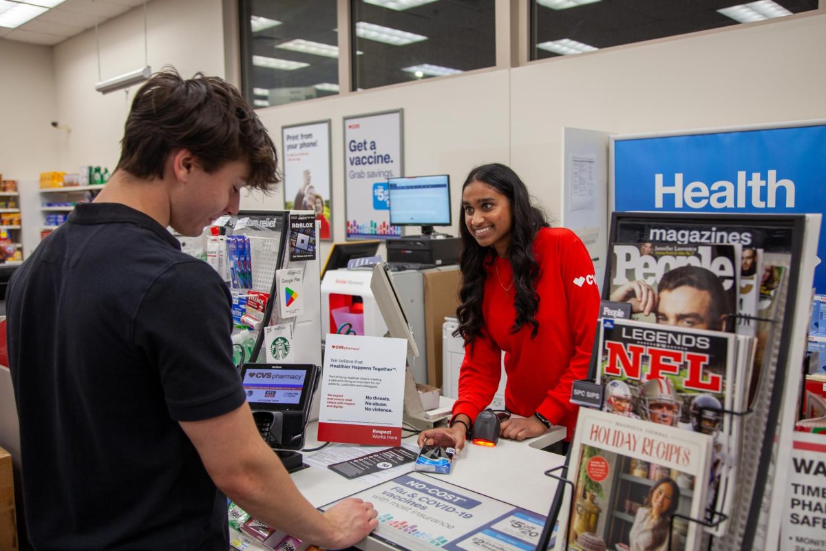 Checking out a customer, senior Shirah Ramaji works behind the counter at CVS Pharmacy. Ramaji believes in the passing of Proposition A during the 2024 election to help uplift minimum wage workers. “I’m going to college next year, and it’s going to be very expensive. It’s infeasible to work long hours to get just a little bit of money,” Ramaji said.  