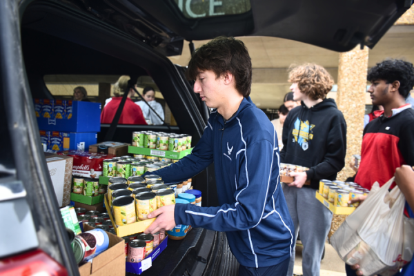 Adding a tray of canned corn to the pile, junior Michael Collop assists in transporting donations for the Holiday Food Drive. The event, hosted schoolwide from Dec. 10-17, raised over 5,000 food items to deliver to the Parkway Food Pantry, helping several families in need. "[The drive] is a great thing for us to do because you're giving to those who are less fortunate, and it helps provide for people who can't provide for themselves. [The] competition is always fun, too. It was fun to be in [social studies teacher Jeff] Chazen’s class, because he always gets worked up over [the competition]. He made it exciting, and was always convincing us to turn in cans for the drive,” Collop said.
